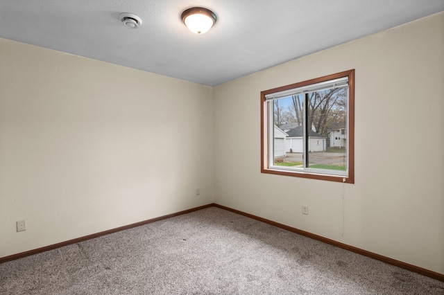 empty room with carpet and baseboards