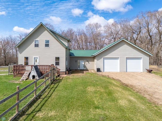 view of front of house featuring metal roof, a front yard, dirt driveway, and fence