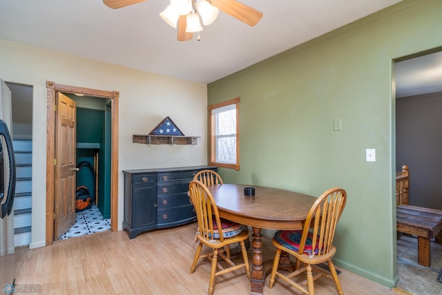 dining space featuring light wood-style floors, a ceiling fan, and crown molding