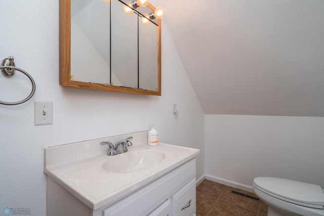 bathroom with vanity, toilet, visible vents, tile patterned flooring, and lofted ceiling