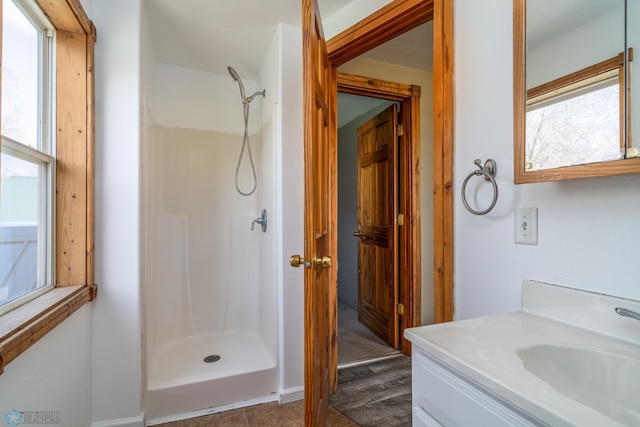 full bath with a shower stall and vanity