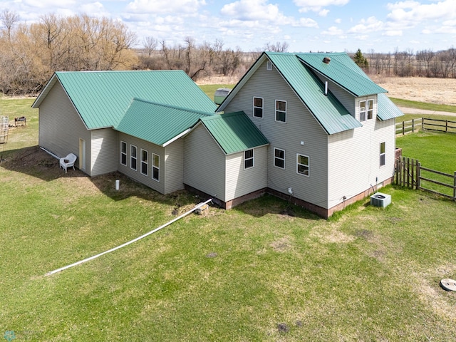 back of house featuring metal roof, a yard, and fence