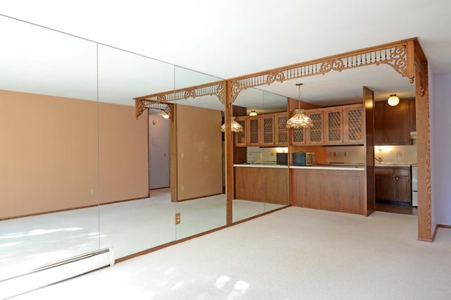 interior space with decorative light fixtures, brown cabinets, a baseboard heating unit, glass insert cabinets, and light carpet