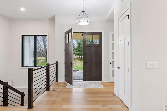 foyer with recessed lighting, stairway, a chandelier, light wood-style flooring, and baseboards