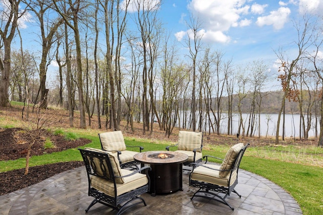 view of patio / terrace with an outdoor fire pit and a water view