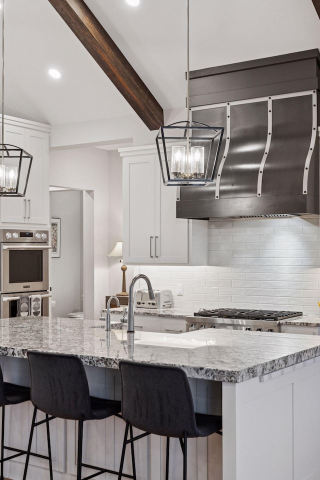 kitchen with white cabinets, stainless steel appliances, tasteful backsplash, and a notable chandelier