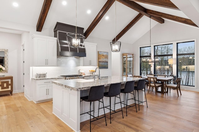 kitchen with white cabinetry, a chandelier, and backsplash