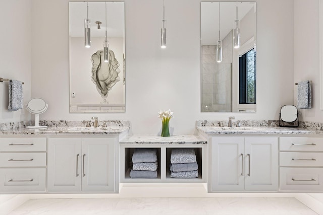 bathroom with walk in shower, two vanities, and a sink