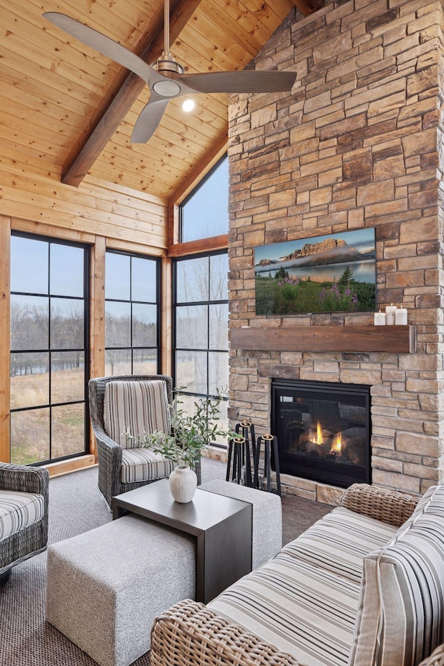 living area featuring ceiling fan, wood ceiling, and beamed ceiling