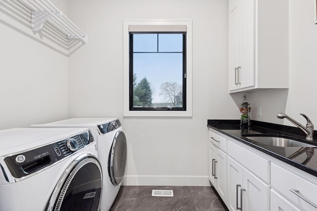 clothes washing area with baseboards, washer and dryer, visible vents, a sink, and cabinet space