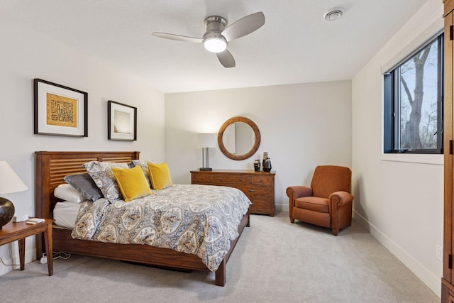 bedroom featuring baseboards, ceiling fan, and light colored carpet