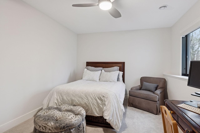 bedroom featuring light colored carpet, baseboards, and a ceiling fan