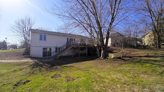 back of property with a lawn, a wooden deck, and stairway