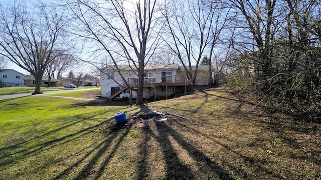 view of front of house with stairs, a front lawn, and a wooden deck