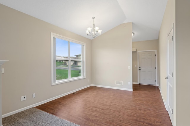 spare room featuring an inviting chandelier, visible vents, lofted ceiling, and dark wood-style floors