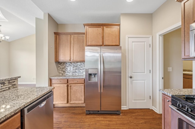kitchen with dark wood-style flooring, light stone countertops, decorative backsplash, and appliances with stainless steel finishes