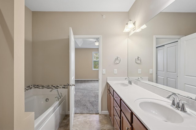 full bath featuring a sink, ceiling fan, double vanity, and a garden tub