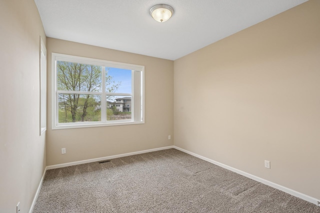 carpeted empty room with baseboards and visible vents