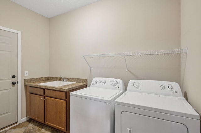 washroom with a sink, separate washer and dryer, and cabinet space