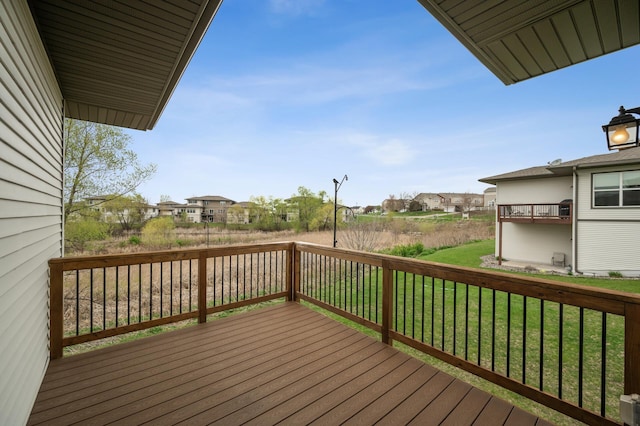 wooden terrace featuring a residential view and a lawn