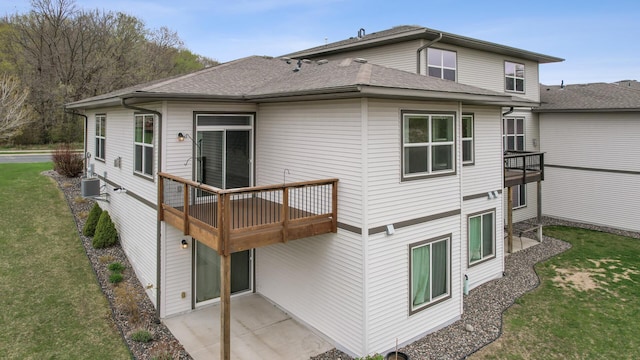 back of property featuring a yard, a shingled roof, a patio, and central AC unit