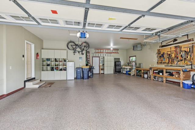 813 Quie Ln, Northfield, MN 55057 - garage with freestanding refrigerator, a garage door opener, and a workshop area