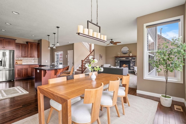 7387 Old Mill Rd, Centerville, MN 55038 - dining room featuring a fireplace, stairway, plenty of natural light, dark wood-style flooring, and recessed lighting