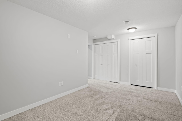 7387 Old Mill Rd, Centerville, MN 55038 - unfurnished bedroom featuring carpet floors, a textured ceiling, and multiple closets