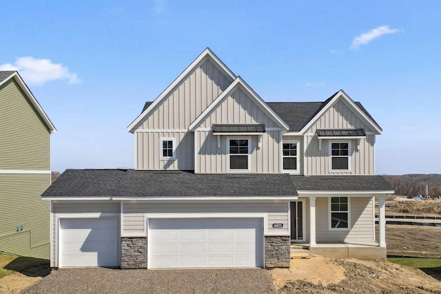 view of front facade featuring board and batten siding, roof with shingles, covered porch, and stone siding