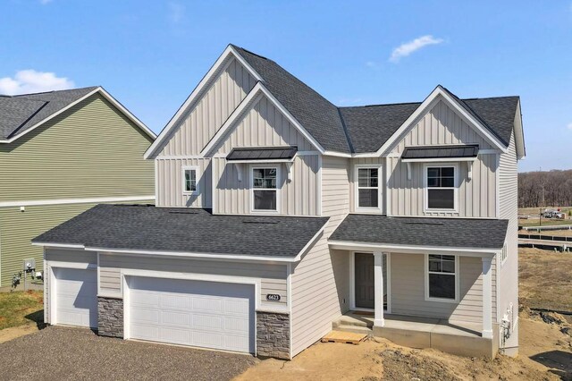 view of front of property featuring board and batten siding, roof with shingles, driveway, and a porch