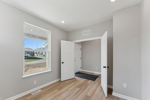 spare room with recessed lighting, baseboards, light wood finished floors, and visible vents