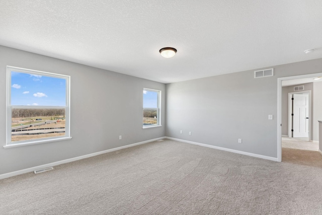 empty room featuring baseboards, visible vents, and carpet