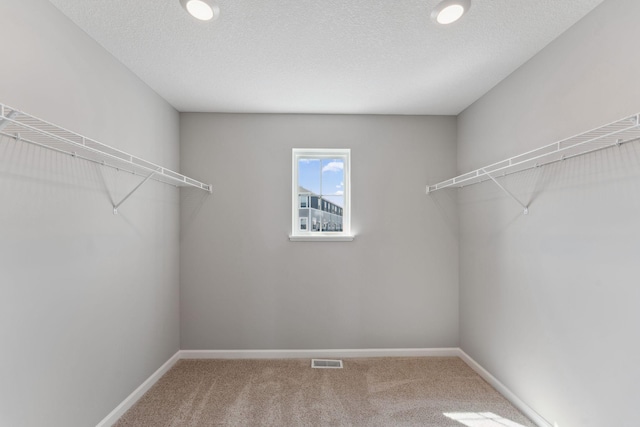 spacious closet featuring visible vents and carpet