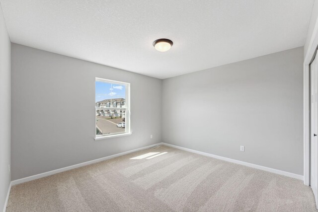 empty room with baseboards and carpet