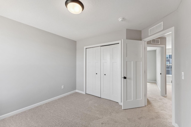 unfurnished bedroom featuring visible vents, carpet flooring, and baseboards