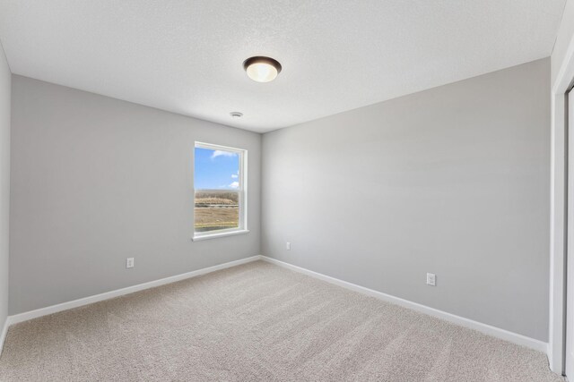 carpeted spare room featuring baseboards