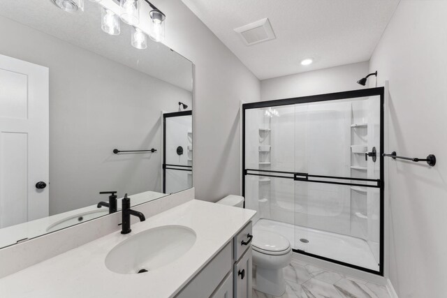 bathroom with vanity, a stall shower, toilet, and marble finish floor