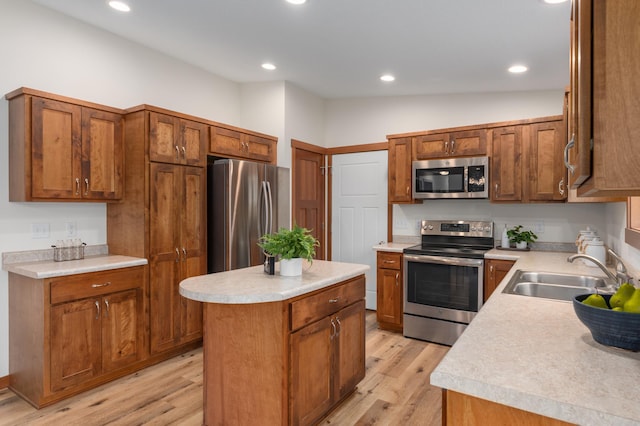 1715 107th St, New Richmond, WI 54017 - kitchen with stainless steel appliances, a sink, a center island, light wood-type flooring, and brown cabinetry