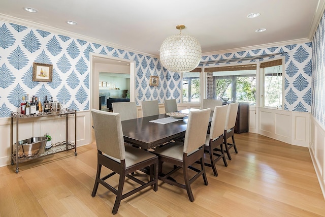 4721 Lake Harriet Pkwy, Minneapolis, MN 55419 - dining area with wallpapered walls, ornamental molding, a wainscoted wall, light wood-style flooring, and a decorative wall