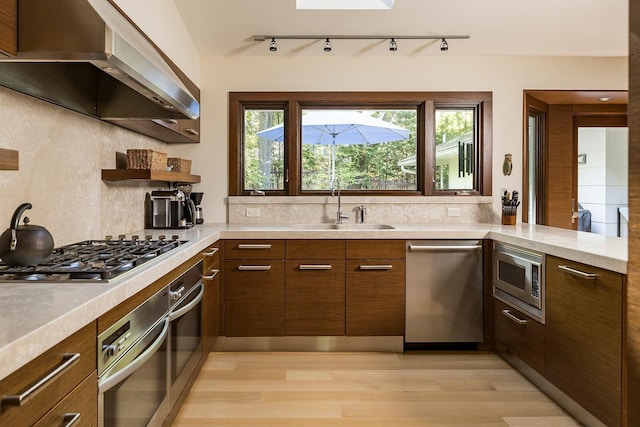 4721 Lake Harriet Pkwy, Minneapolis, MN 55419 - kitchen with appliances with stainless steel finishes, range hood, light countertops, and light wood-type flooring