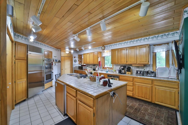 7717 Lake May Rd NW, Walker, MN 56433 - kitchen with tile counters, rail lighting, stainless steel appliances, light tile patterned floors, and wood ceiling