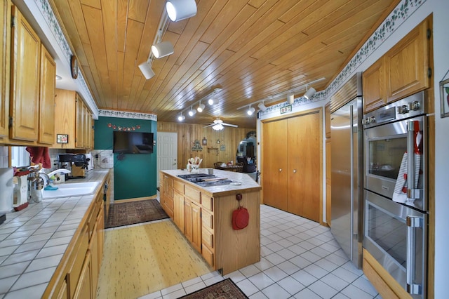 7717 Lake May Rd NW, Walker, MN 56433 - kitchen with tile counters, a sink, appliances with stainless steel finishes, wooden ceiling, and light tile patterned floors