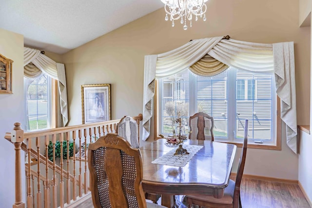 dining area with baseboards, wood finished floors, and a notable chandelier