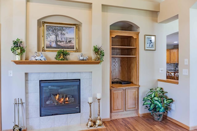 interior space featuring baseboards, wood finished floors, and a tile fireplace