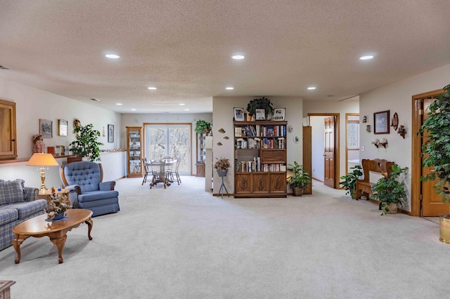 living room with carpet floors, recessed lighting, and a textured ceiling