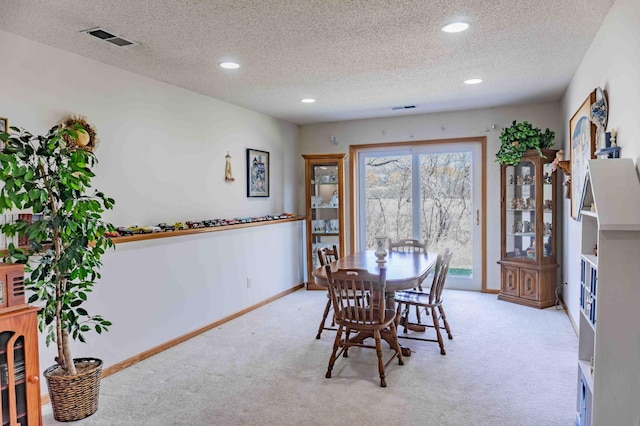 dining space with light colored carpet, a textured ceiling, visible vents, and recessed lighting
