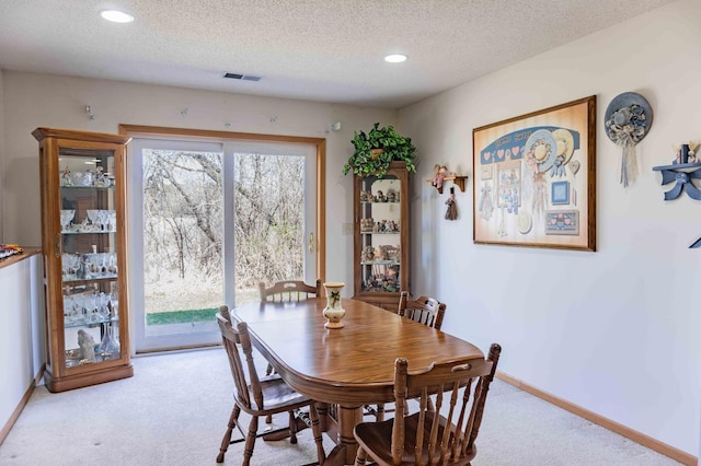dining space featuring a textured ceiling, visible vents, baseboards, carpet flooring, and recessed lighting