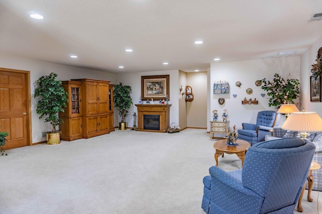 living area featuring recessed lighting, baseboards, a glass covered fireplace, and light carpet