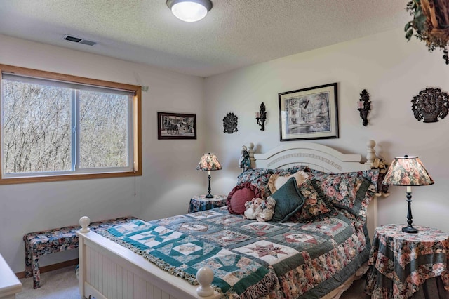 bedroom with baseboards, carpet, a textured ceiling, and visible vents