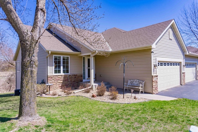single story home featuring a garage, a front yard, driveway, and stone siding